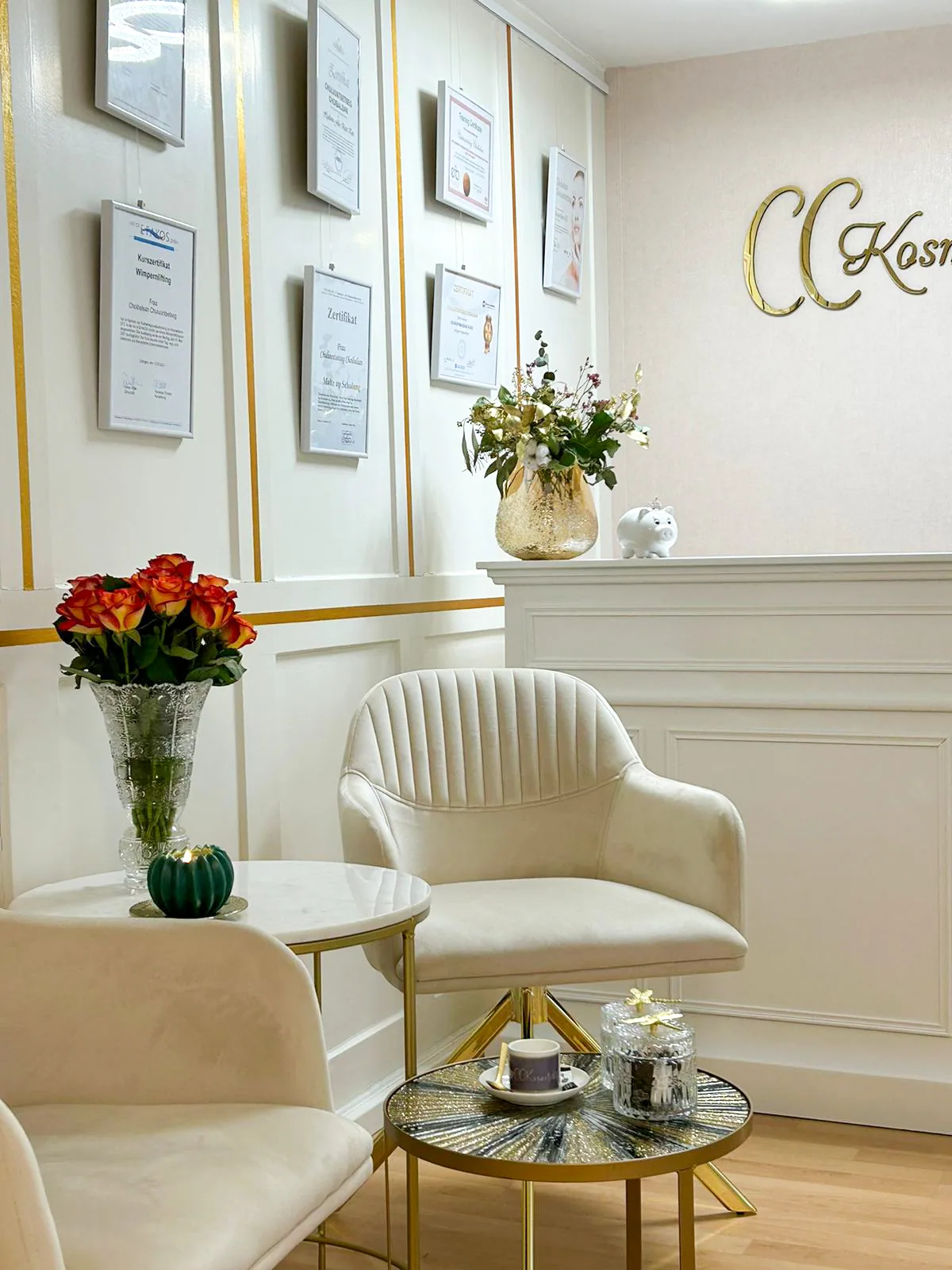 Behandlungsraum von CCKosmetik mit goldenem Logo, Sesseln und Rosen